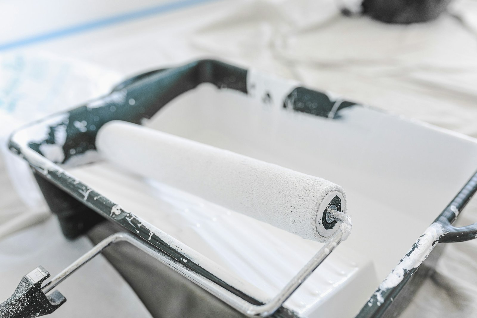 Close-up of a roller loaded with white waterproof coating